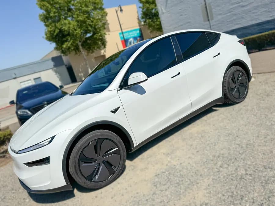 White Tesla Model Y side profile with tinted windows at OC House of Tint
