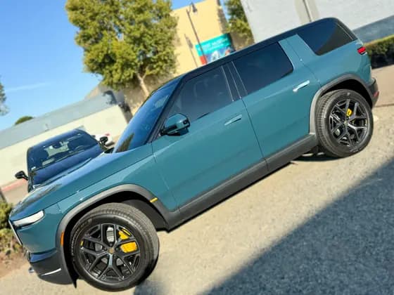 Teal Rivian R2 viewed along the driver side at OC House of Tint