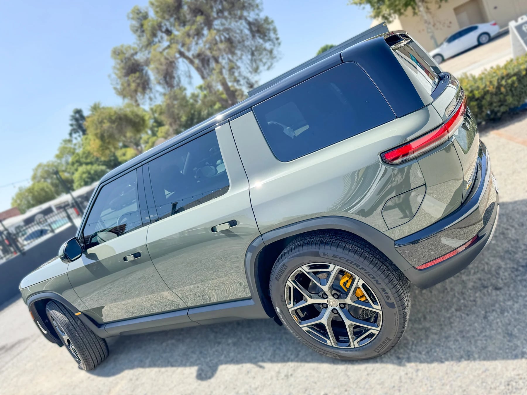 Rear view of the same green Rivian R2 after ceramic window tint installation