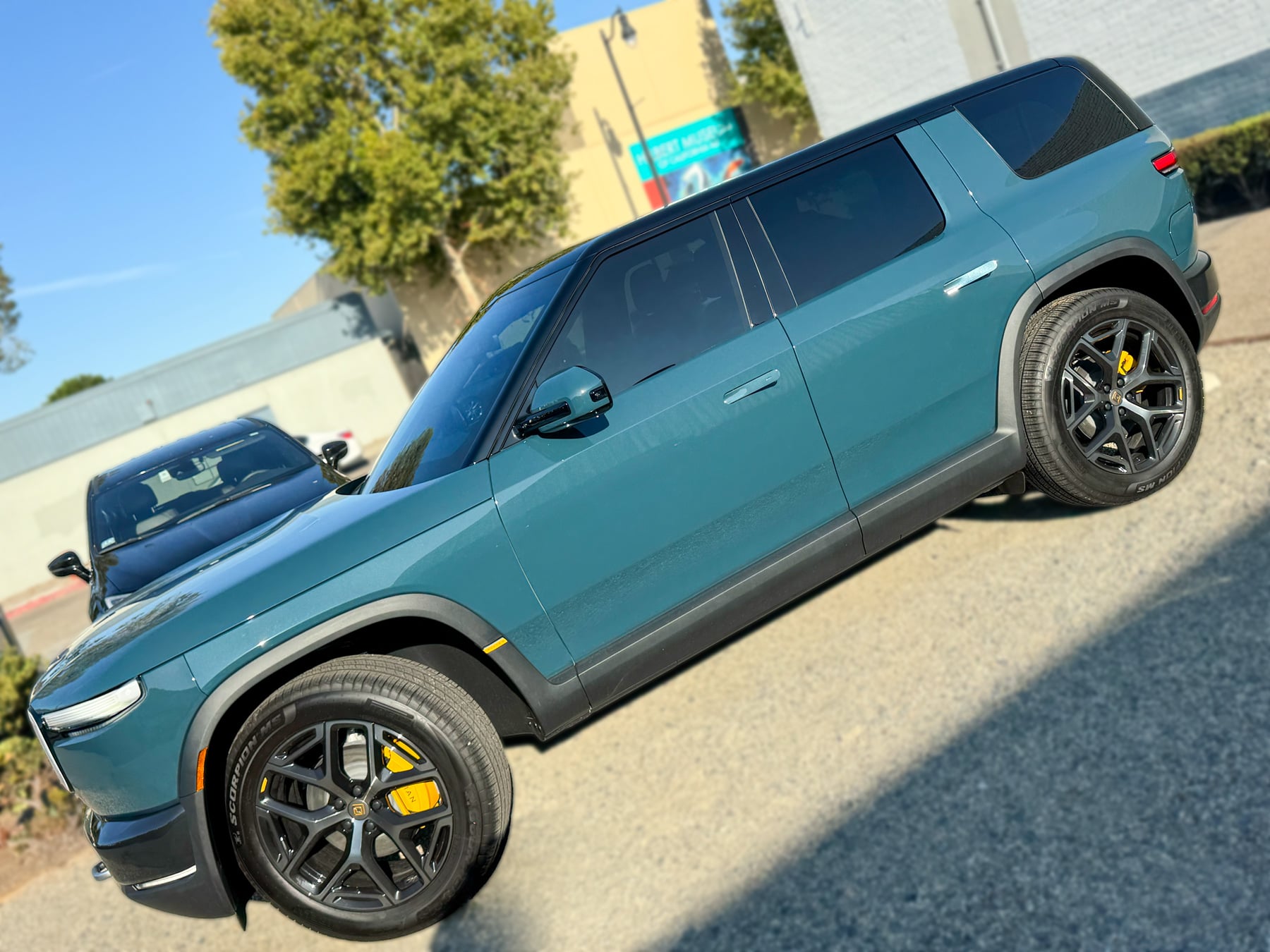 Teal Rivian R2 viewed along the driver side at OC House of Tint