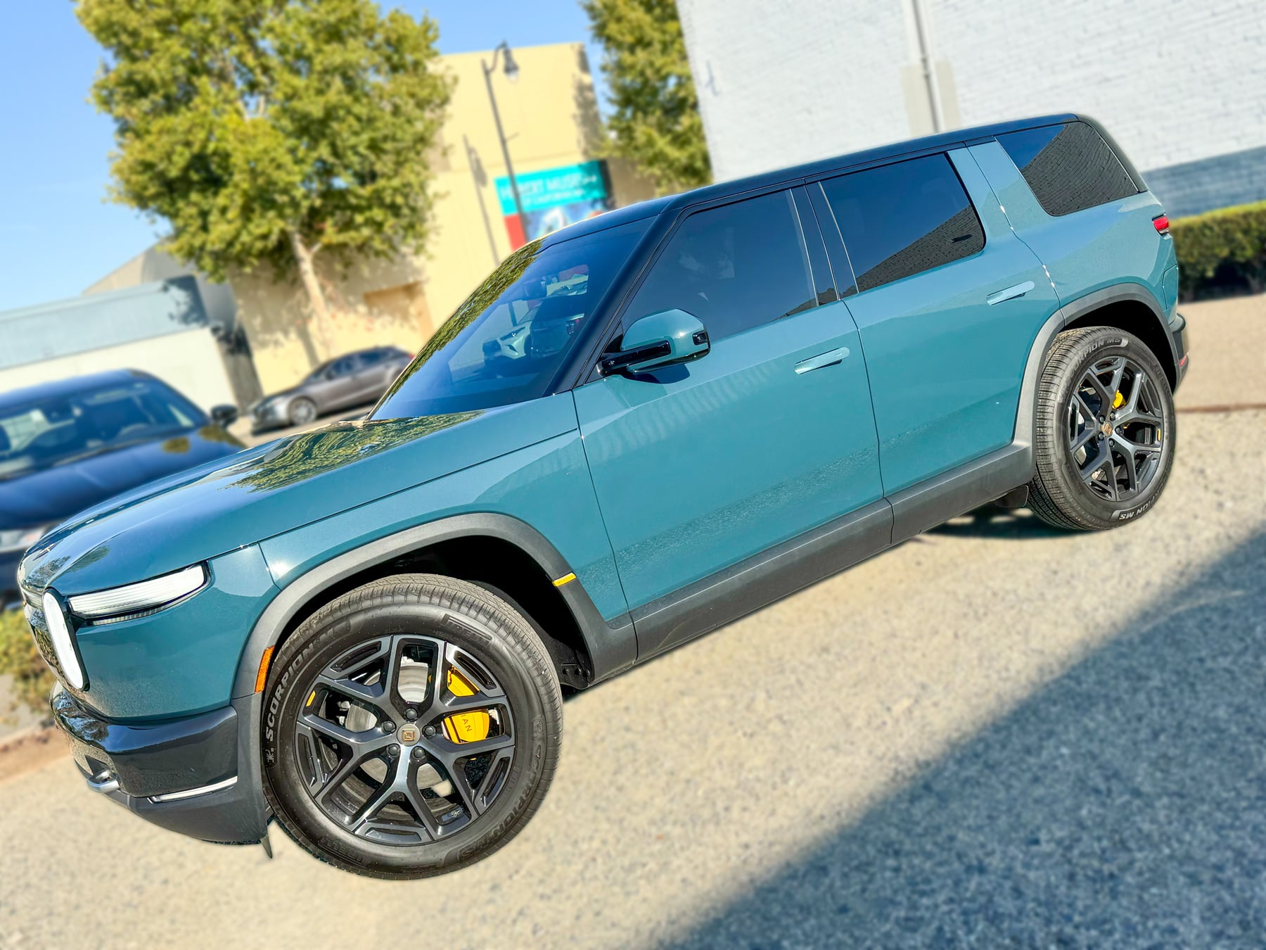 Teal Rivian R2 side profile with dark rear glass at OC House of Tint