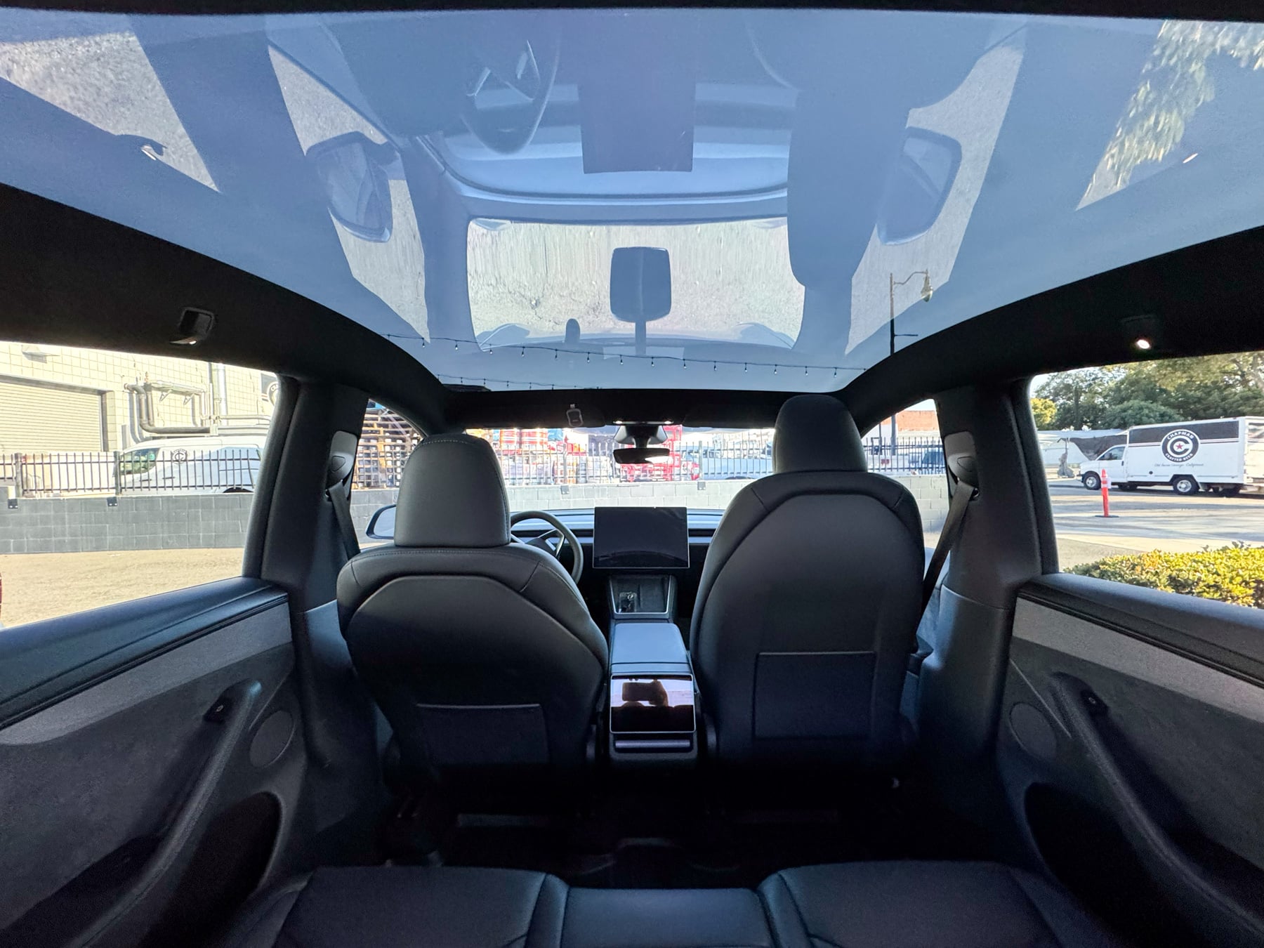 Tesla Model Y rear cabin showing the panoramic glass roof and front seats