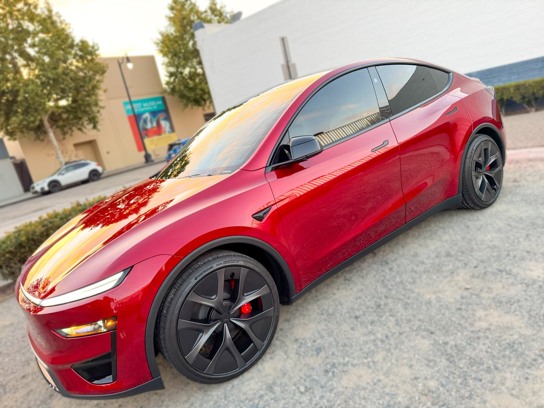 Red Tesla Model Y driver-side profile at OC House of Tint