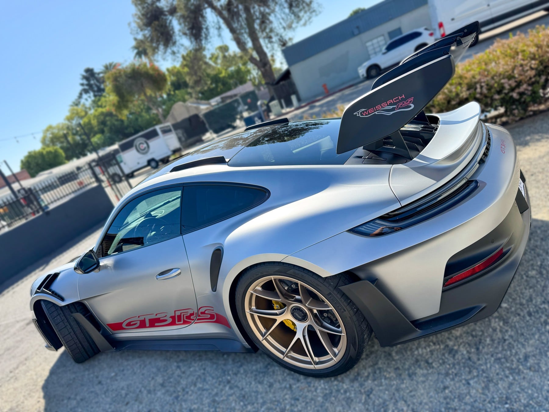 Rear three-quarter view of the silver Porsche 911 GT3 RS and its tinted side glass