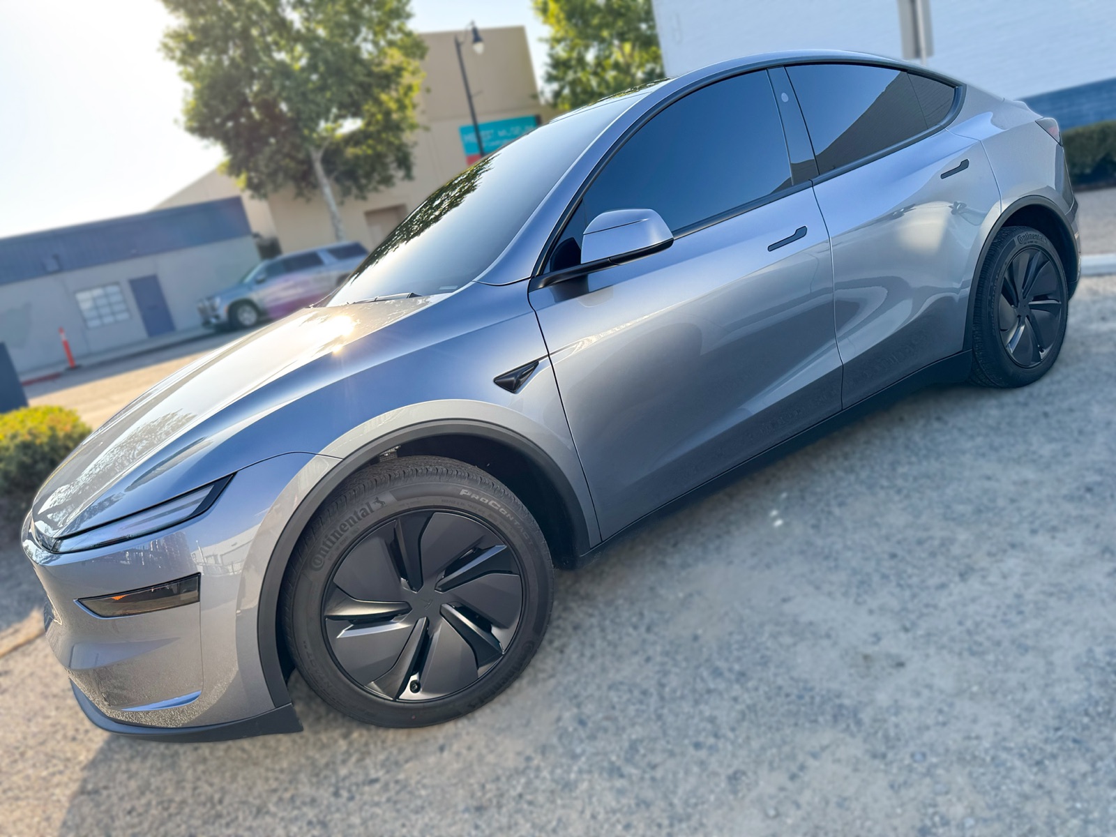 Gray Tesla Model Y side profile with window tint installed by OC House of Tint